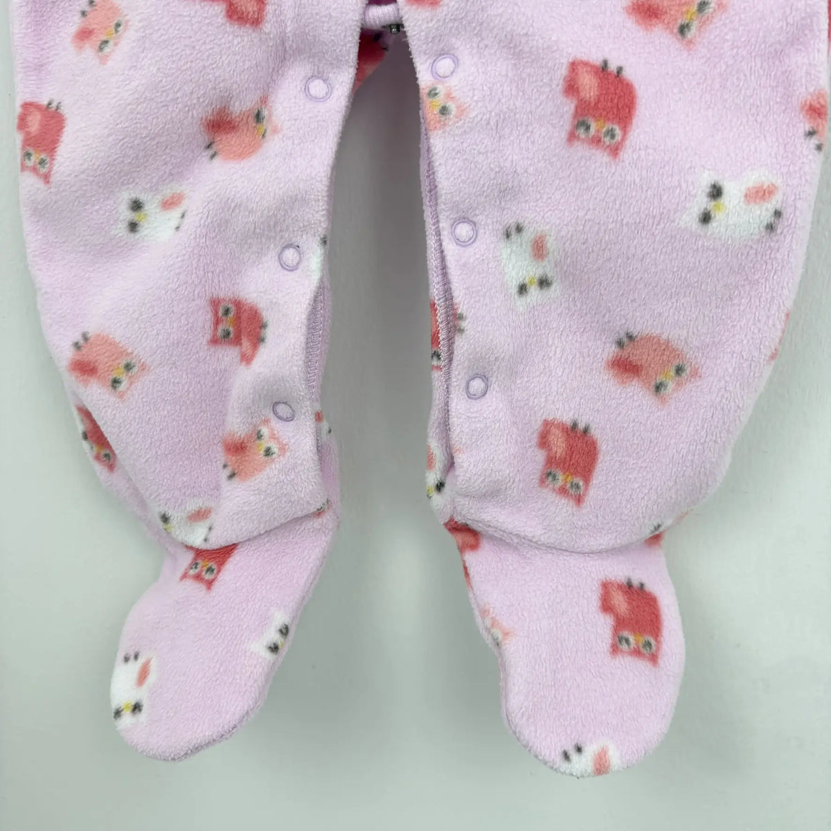 Talpas kialakítás és patentos záródás a rózsaszín rugdalózón