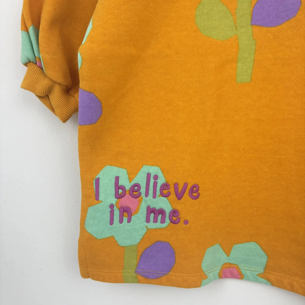 Mustársárga Next pulóver színes virágmintával és I believe in me felirattal