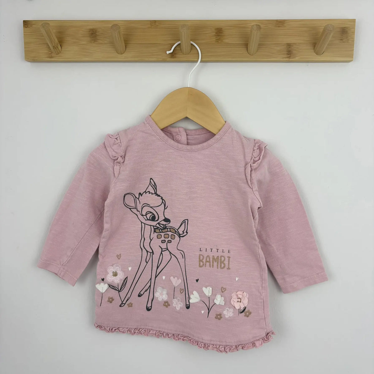 Közeli kép a rózsaszín felső Bambi mintájáról és vállfodráról