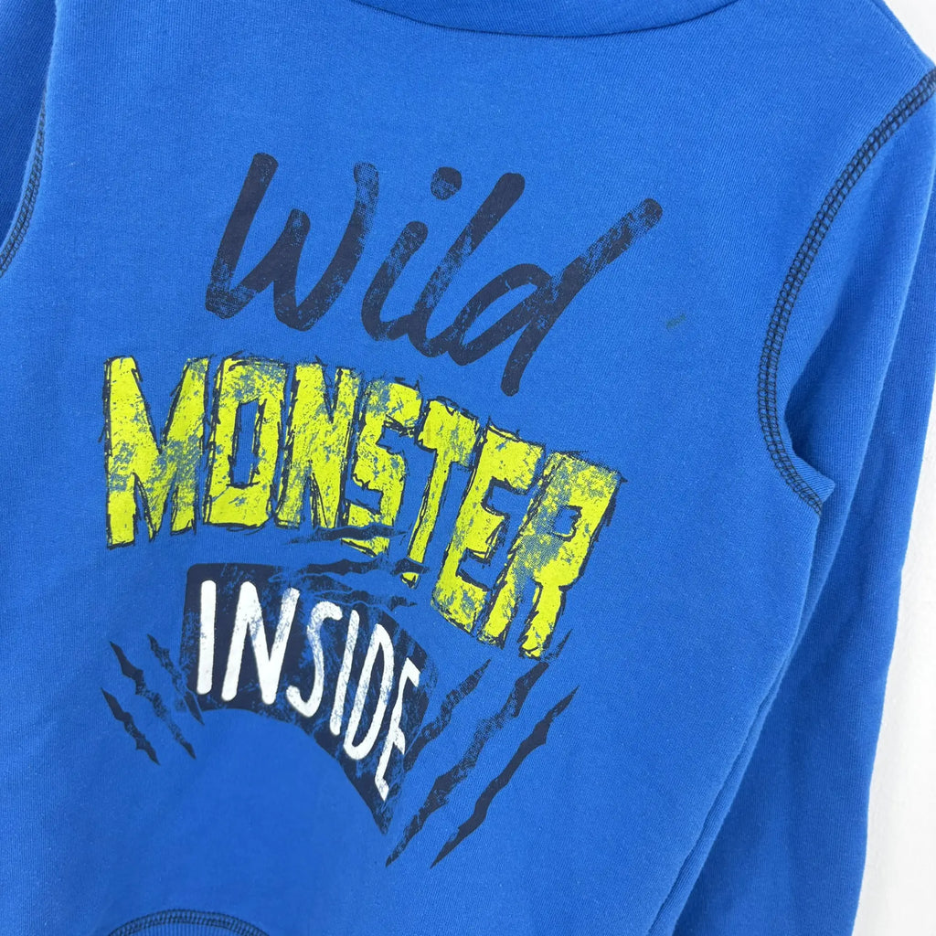 A pulóver Wild Monster Inside felirata és karmolásmintája közelről
